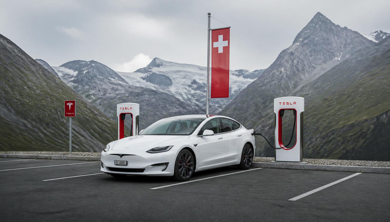 Weisser Tesla am Supercharger in den Schweizer Bergen